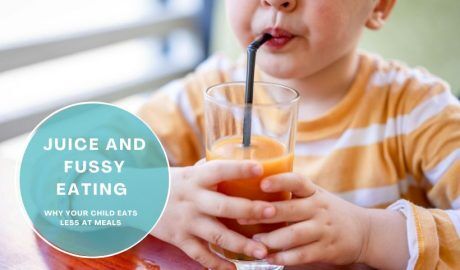 Child drinking fruit juice at the table instead of eating a meal