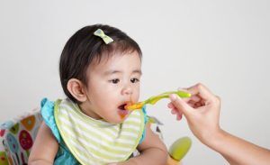 Baby leans forward happy to be fed